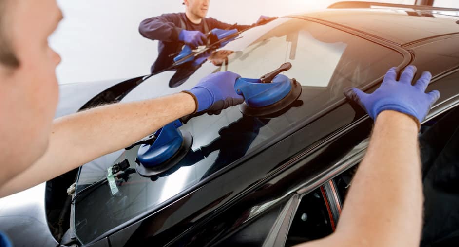 automobile special workers replacing windscreen of a car in auto service