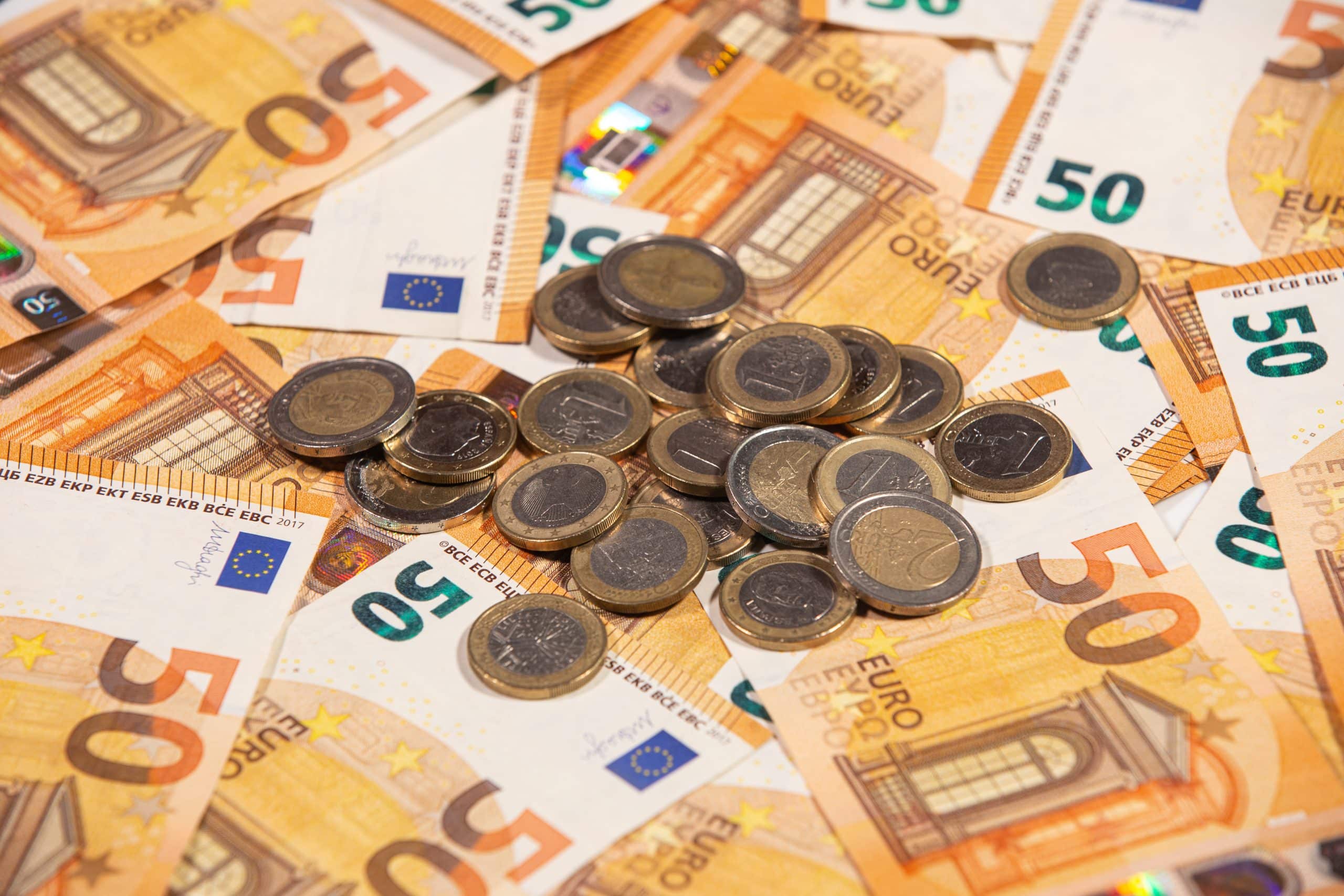 closeup of fifty euro bills and coins.