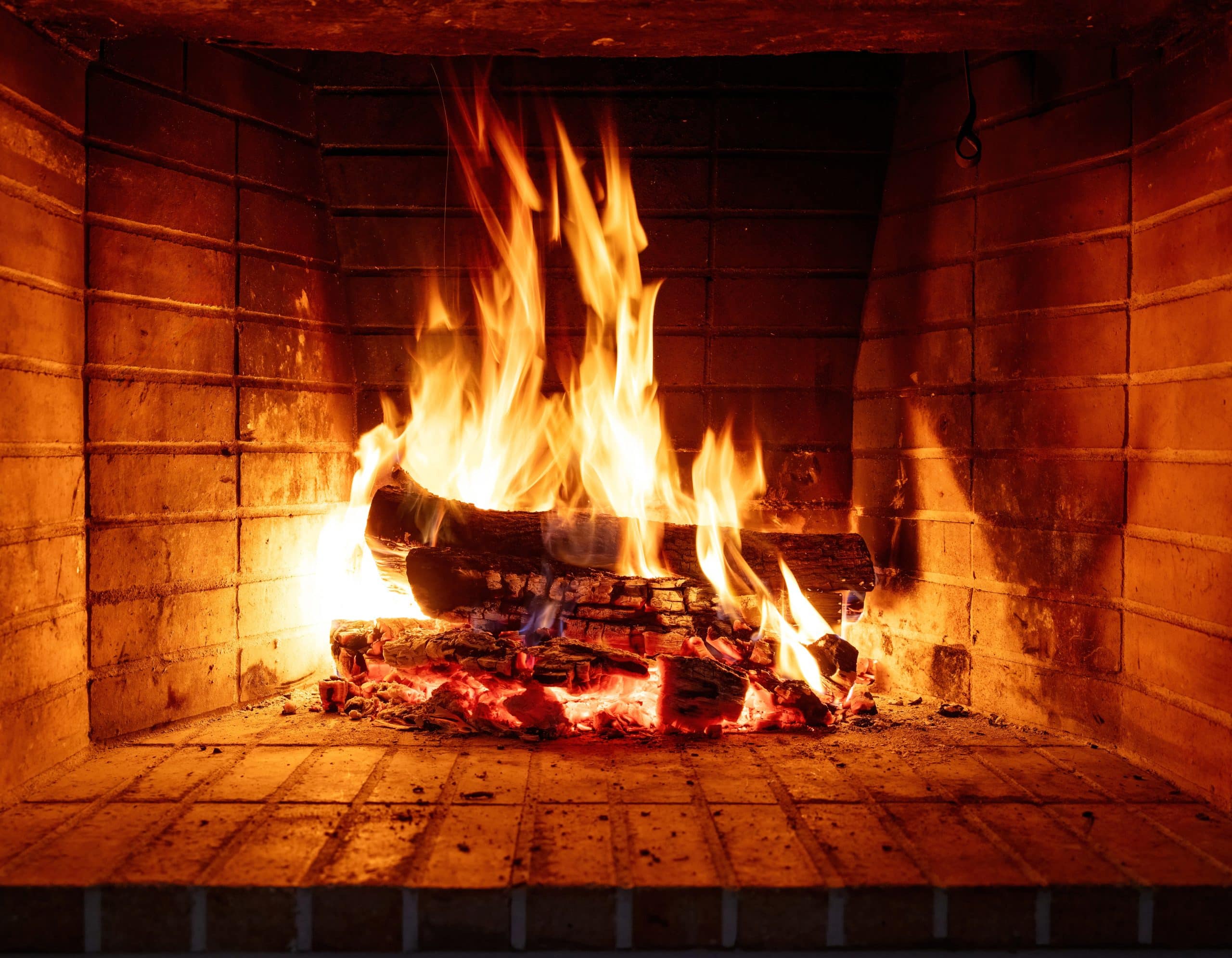 fire burning in a fireplace, wood logs and flames. warm home, heat. christmas holiday
