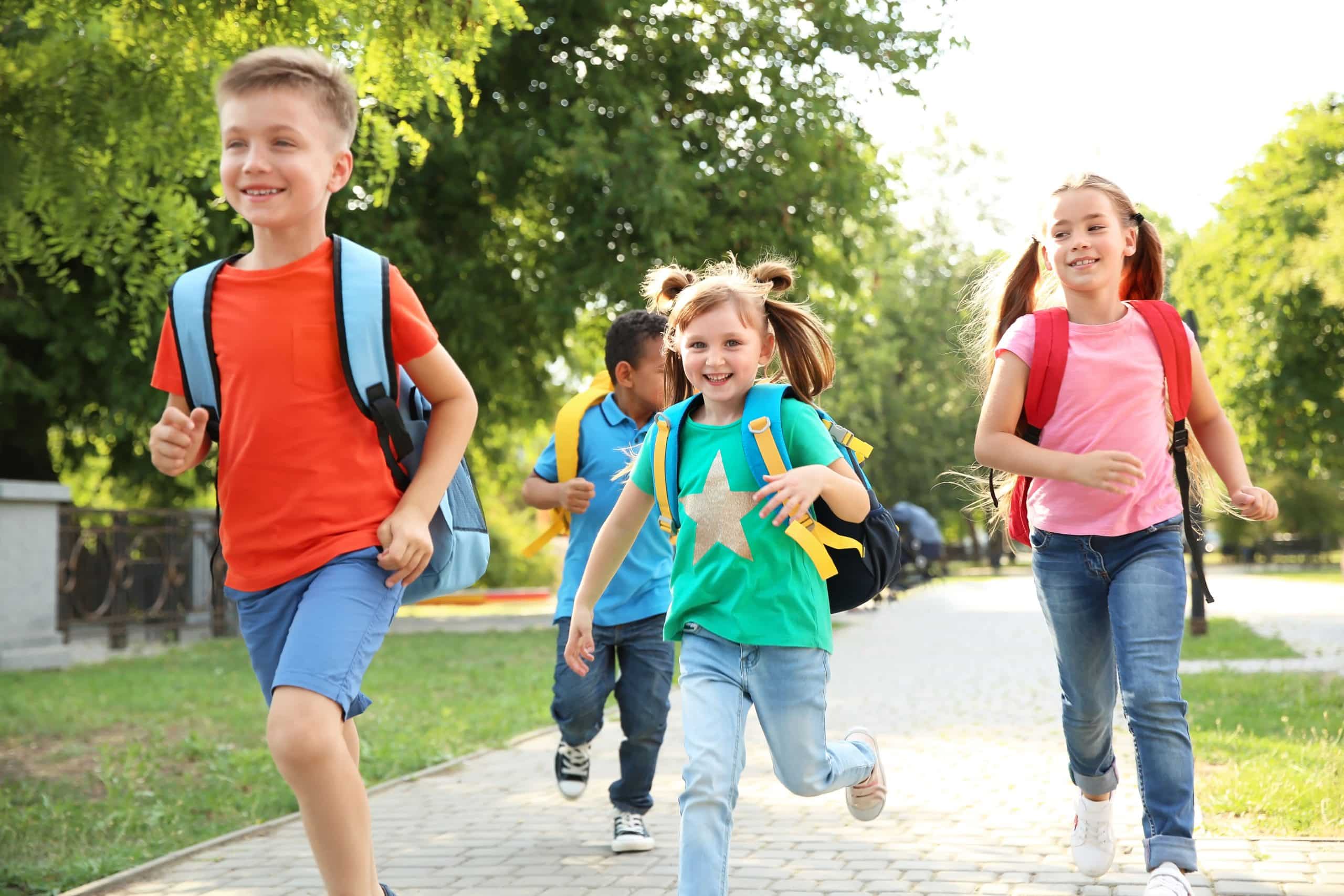 cute,little,children,with,backpacks,running,outdoors.,elementary,school