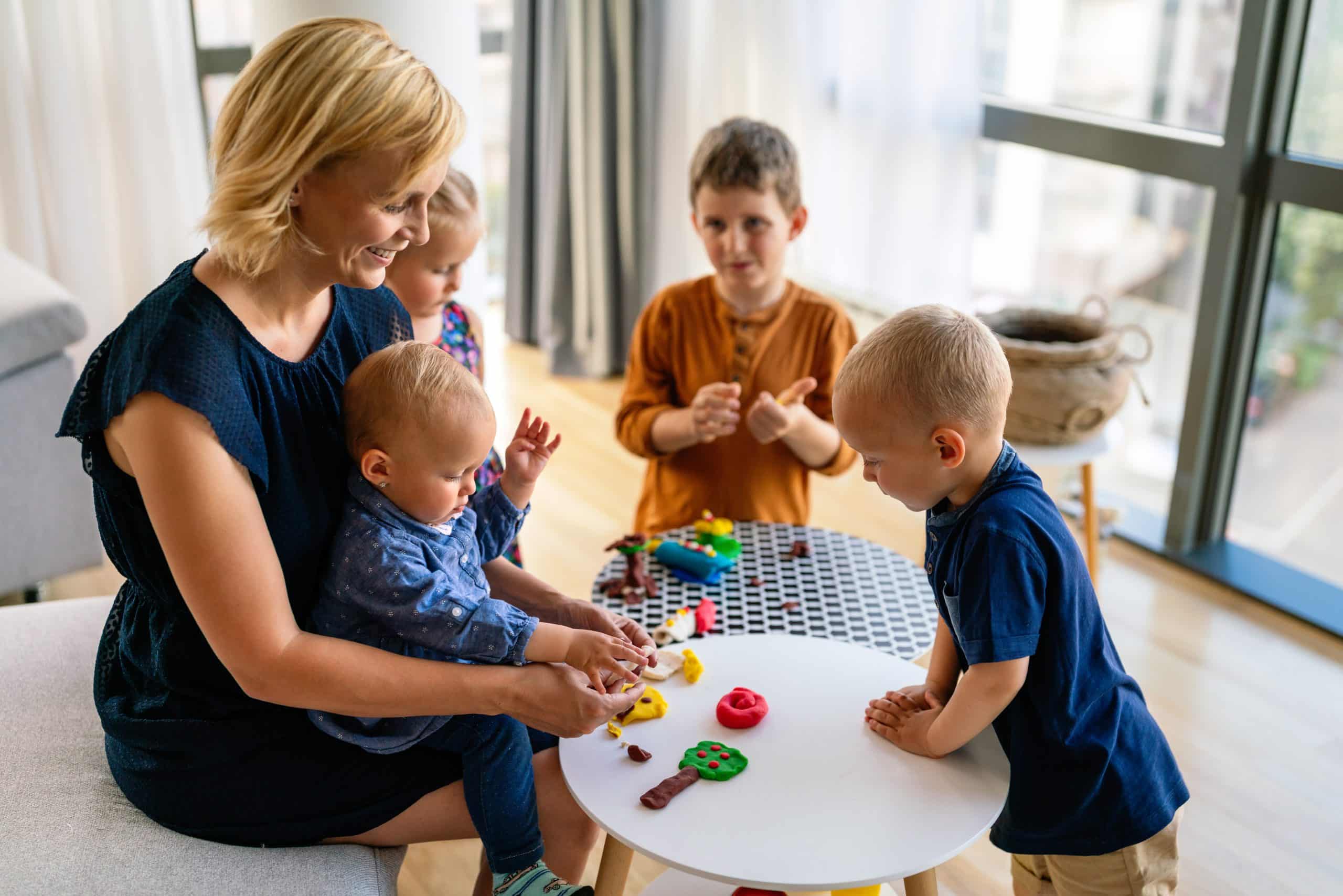family, children, education, happiness concept. mother teaches preschooler kids to do craft items.