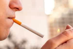 smoking concept. man lighting a cigarette with a lighter. smoking a cigarette close up.