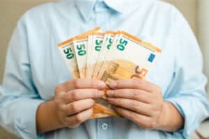 money winner. businesswoman hands with euro money on grey background