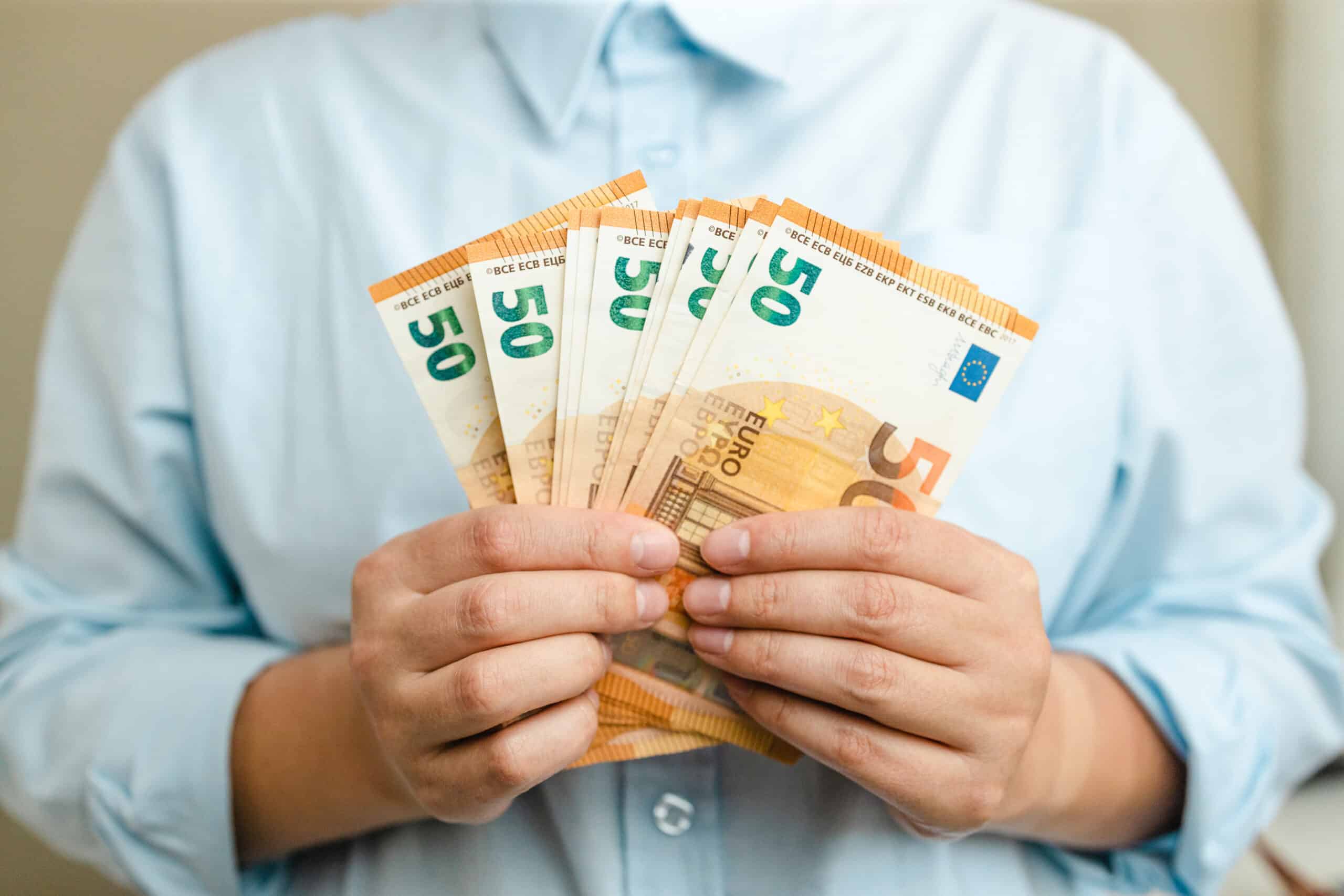 money winner. businesswoman hands with euro money on grey background